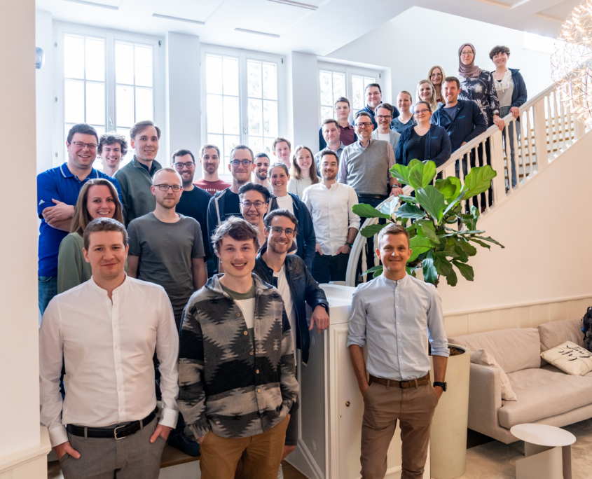 Man sieht ein Bild des gesamten scieneers-Teams. Menschen stehen auf einer großen, ausladenden Treppe und schauen alle in die Kamera.