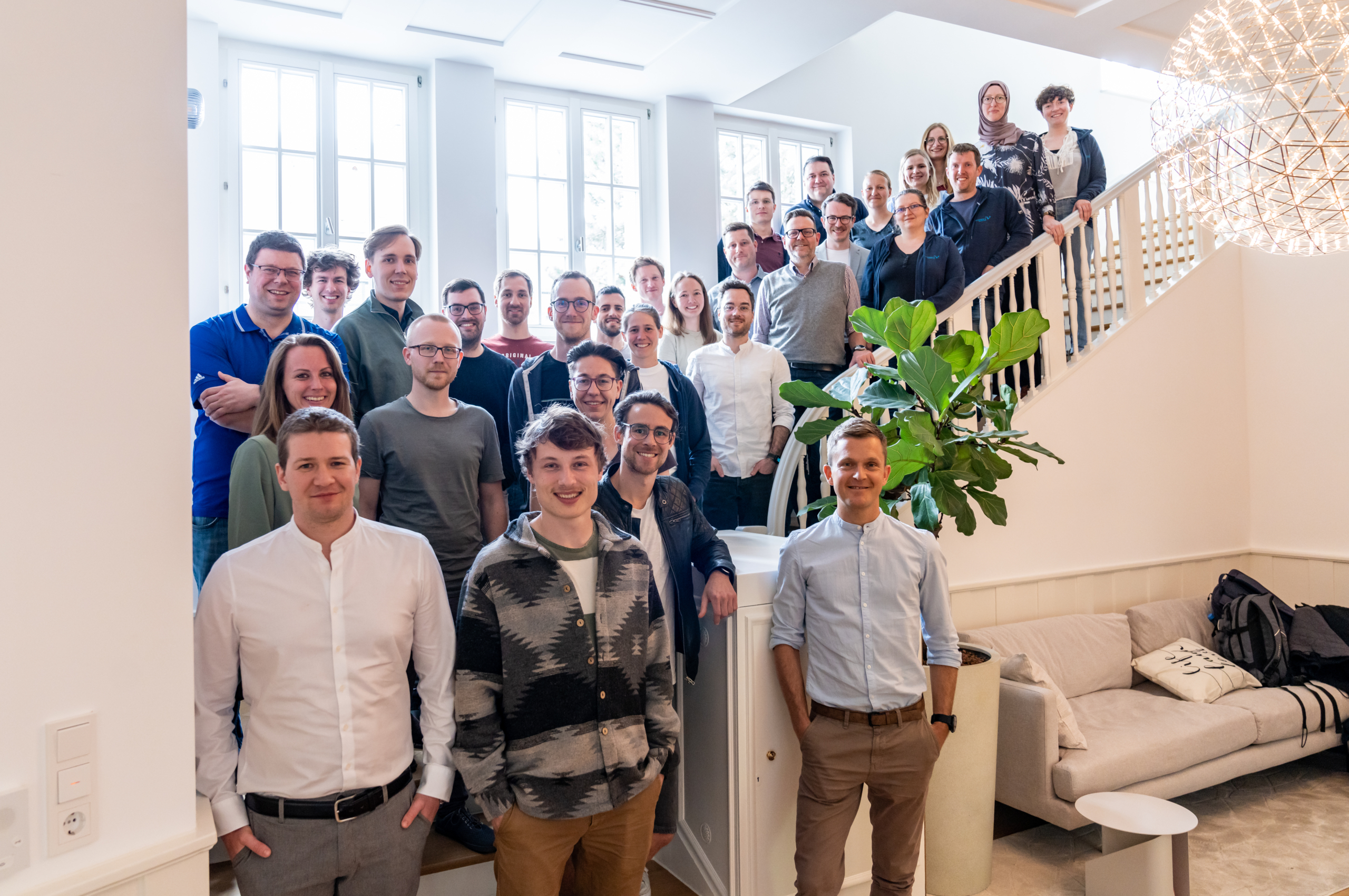 Man sieht ein Bild des gesamten scieneers-Teams. Menschen stehen auf einer großen, ausladenden Treppe und schauen alle in die Kamera.